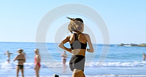 Fit woman jogging in the beach 4k