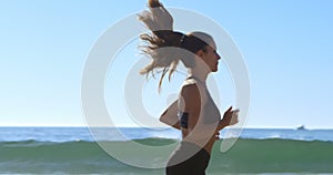 Fit woman jogging in the beach 4k