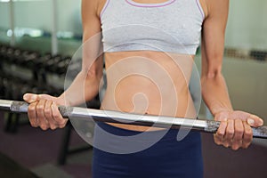 Fit woman lifting barbell weight