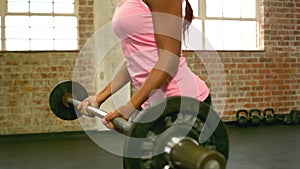 Fit woman lifting barbell weight