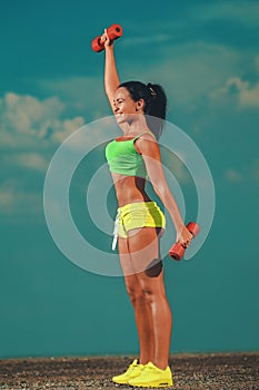 Fit woman lifting dumbbells