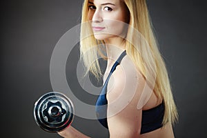 Fit woman lifting dumbbells weights