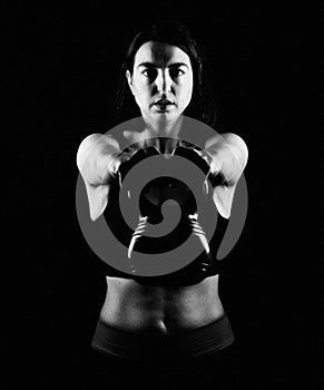 Fit woman lifting kettle bell photo