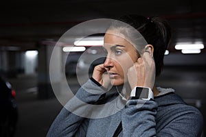 Fit woman listening to music in underground parking area