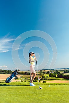 Fit woman looking at the horizon on the green grass of a golf course