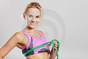 Fit woman measuring her chest breasts with tape measure