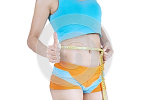 Fit woman measuring her waist