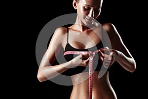 The fit woman measuring perfect shape of beautiful body. Healthy lifestyles concept