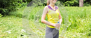 Fit woman outdoors holding a bottle of water