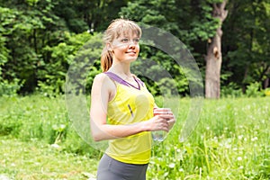 Fit woman outdoors holding a bottle of water