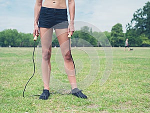 Fit woman in park with jump rope