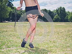 Fit woman in park with jump rope