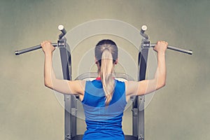 fit woman performing pull ups in a bar. Hard training. Rear view