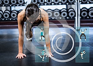 Fit woman performing push up exercise at gym against fitness interfare in background