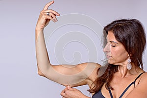 Fit woman pinching the skin of her upper arm