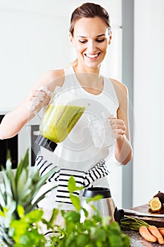 Fit woman pouring green cocktail