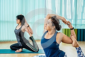 Fit woman practice yoga with friends, Young, woman in yoga class making beautiful asana exercises. Girl do mermaid pose