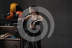 Fit woman practicing on airbike at gym