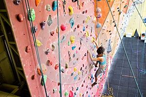 Fit woman rock climbing indoors