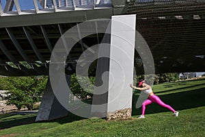 Fit woman runner stretching outdoors