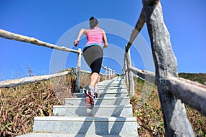 Fit woman running up on mountain stairs