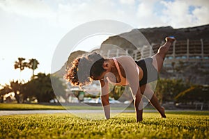 Fit woman in sportswear doing yoga alone in a park