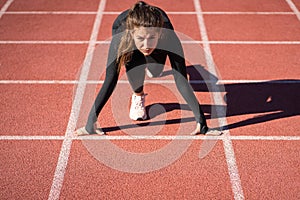 Fit woman sprinter on a treadmill rubber stadium or running track getting ready to start run