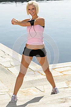 Fit woman stretch body by water pier