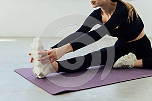 Fit woman stretching her leg to warm up isolated over white background