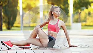 Fit woman stretching legs and make body twisting in park