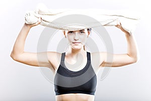 Fit woman after training wiping face with towel