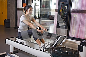 Fit woman using the rowing machine at the gym