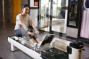Fit woman using the rowing machine at the gym
