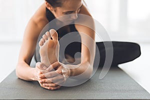 Fit woman warmup stretching, training indoors, focus on foot