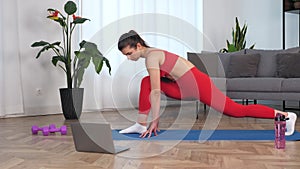 Fit woman watch online sport webinar laptop, doing warm-up stretching training