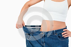 Fit woman wearing too large jeans