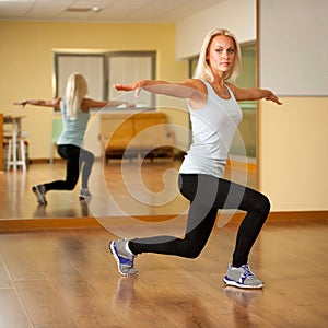 Fit woman work out in gym making lunge step
