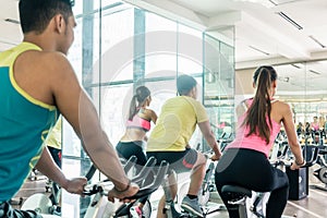 Fit women burning calories during indoor cycling class