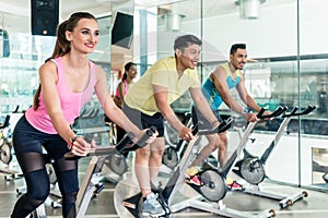 Fit women burning calories during indoor cycling class