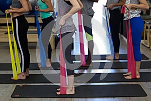 Fit women performing stretching exercise with resistance band