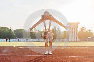 Fit women at the stadium playing leap frog.