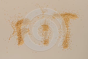 Fit written with yellow quinoa on white table