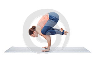Fit yogini woman practices yoga asana Bakasana