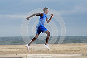 Fit young african man running along the beach