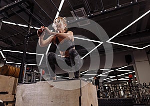 Fit young ambitious woman doing a box jump exercise.