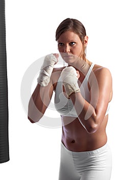 Fit young caucasian woman punching the bag