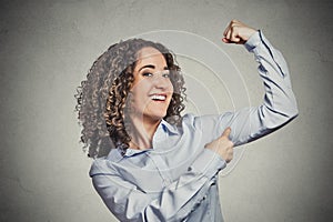 Fit young healthy model woman flexing muscles showing her strength