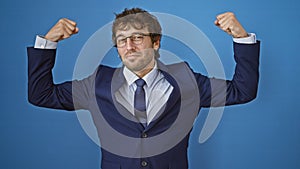 Fit young hispanic man proudly flexes arm muscles in business suit, flaunting strength and confidence. portrait of this bearded