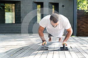 Fit young man exercising with push-ups in the outdoor setting