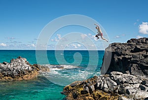 Fit young man jumps into ocean at Lumahai beach Kauai